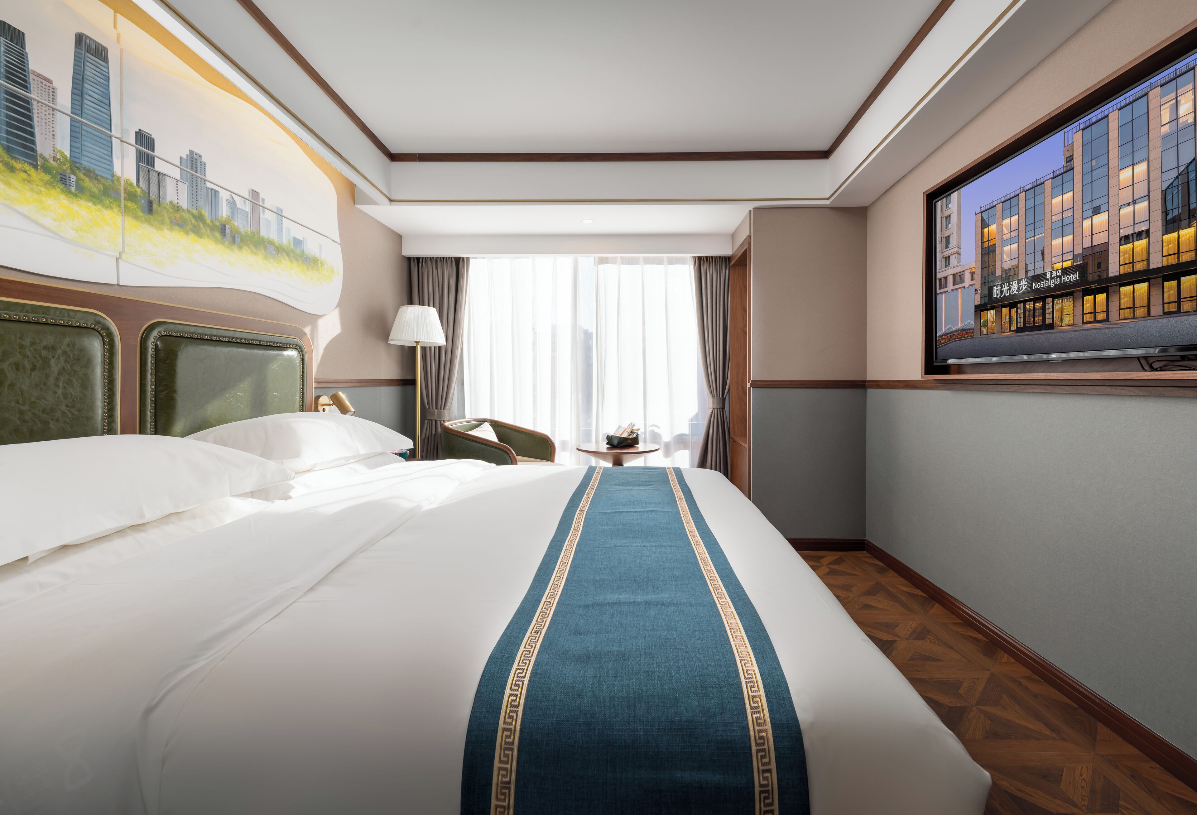 Quarto de hotel com cama grande, um mural da paisagem urbana na parede, televisão e janela com cortinas.