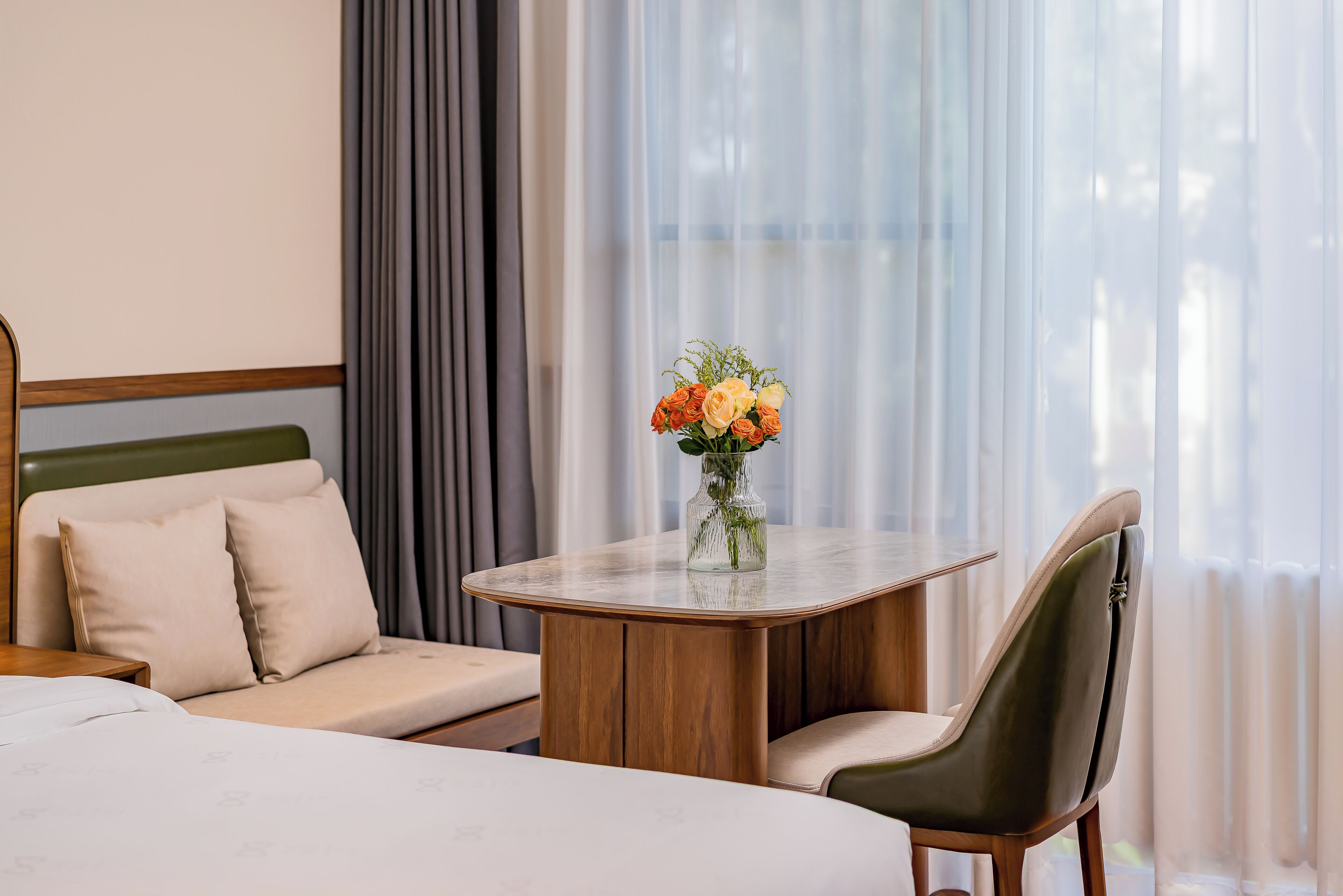 Una habitación de hotel con una cama, un sofá, una mesa de comedor y una silla.