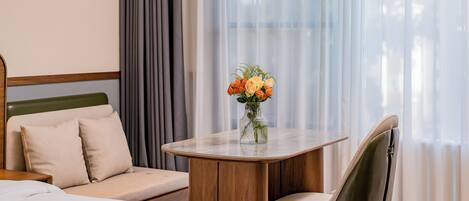 Una habitación de hotel con una cama, un sofá, una mesa de comedor y una silla.