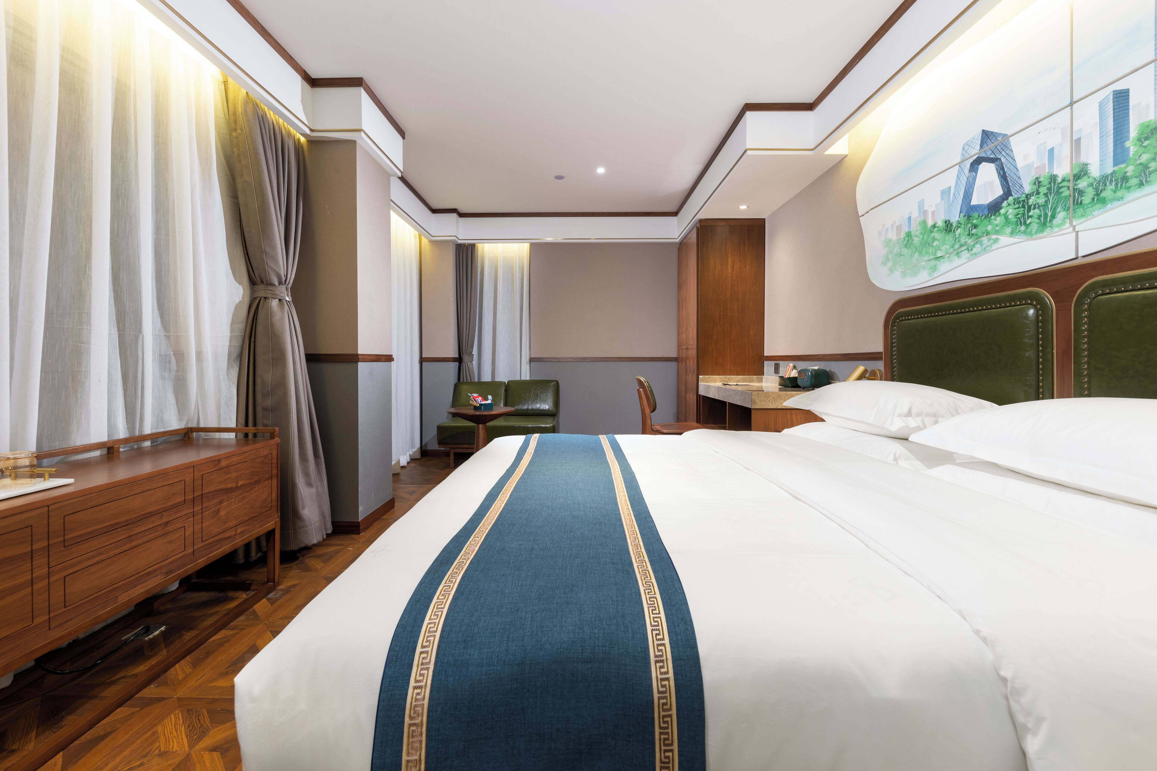 A hotel room with a large bed, wooden furniture, a desk, and a chair.