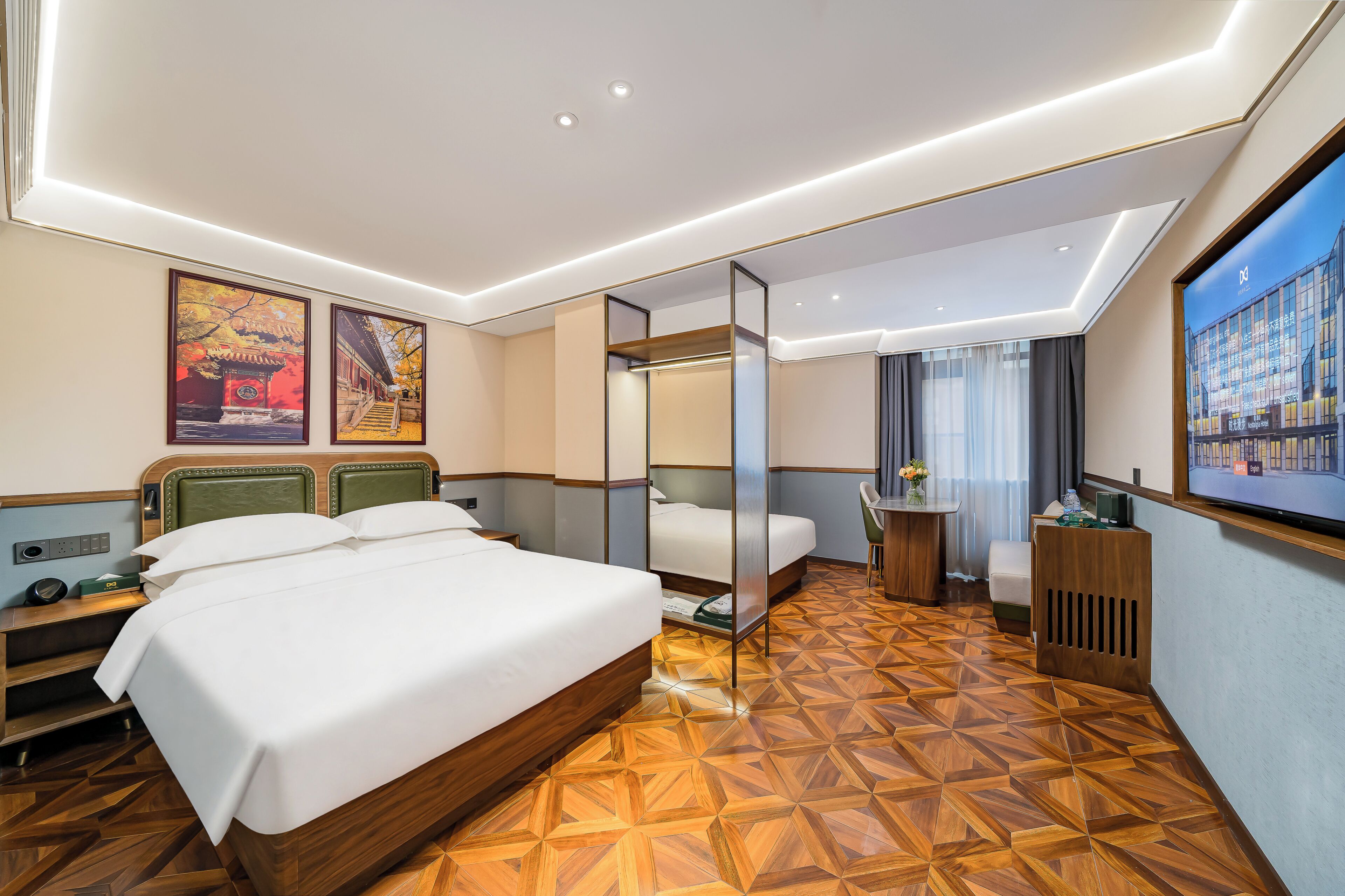 A hotel room with a large bed, a desk, a chair, a small table, and a TV.