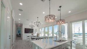 A spacious kitchen with a large island, pendant lights, and a view of the ocean. - Beach Country 7 BR/ 7.5 House w/ Heated Pool (Navarre Beach)