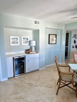 A kitchen with white cabinets, a dishwasher, and a dining area with a table and chairs.