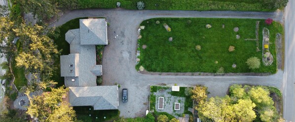 Vue aérienne d’un quartier résidentiel avec une maison, une allée et une pelouse bien entretenue.