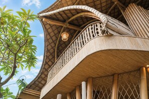 Eine traditionelle Bambuskonstruktion mit einem geschwungenen Balkon und einer hängenden Leuchte.
