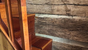 A wooden staircase with a handrail and steps made of wood. - Charming Log Cabin Retreat with Flower Garden (McKenzie)