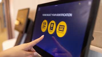 Un quiosco digital con opciones para buscar pasaportes, identificaciones y un teclado para ingresar un PIN.