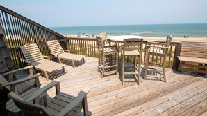 A wooden deck with lounge chairs and a table, overlooking a beach. - OCEANFRONT, 4 BRs, Ocean Views, NP13-2, Summer Wind (Duck)