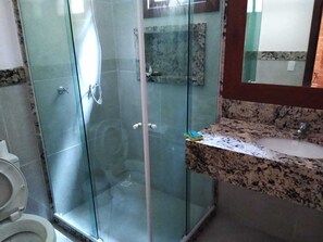 Bathroom features a glass-enclosed shower, granite countertop, and a toilet.