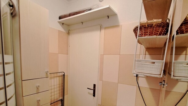 A bathroom with a white sink, a mirror, a towel rack, and a shower area. - 1 Bed, Sleeps 2, Free Parking (Novigrad)