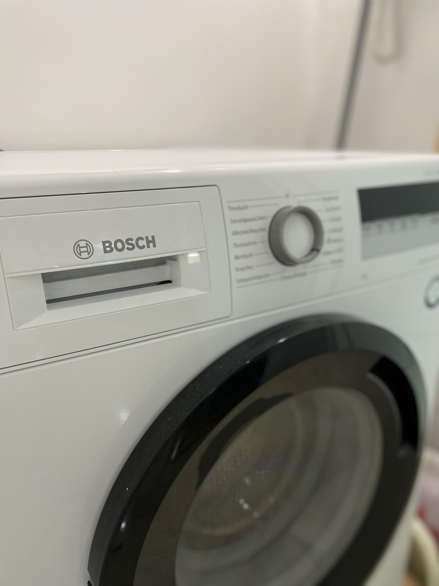 Eine weiße Bosch Waschmaschine mit Bedienfeld und einer Frontlader-Türe.