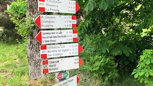 Un poste indicador direccional con varios destinos y tiempos estimados de viaje.