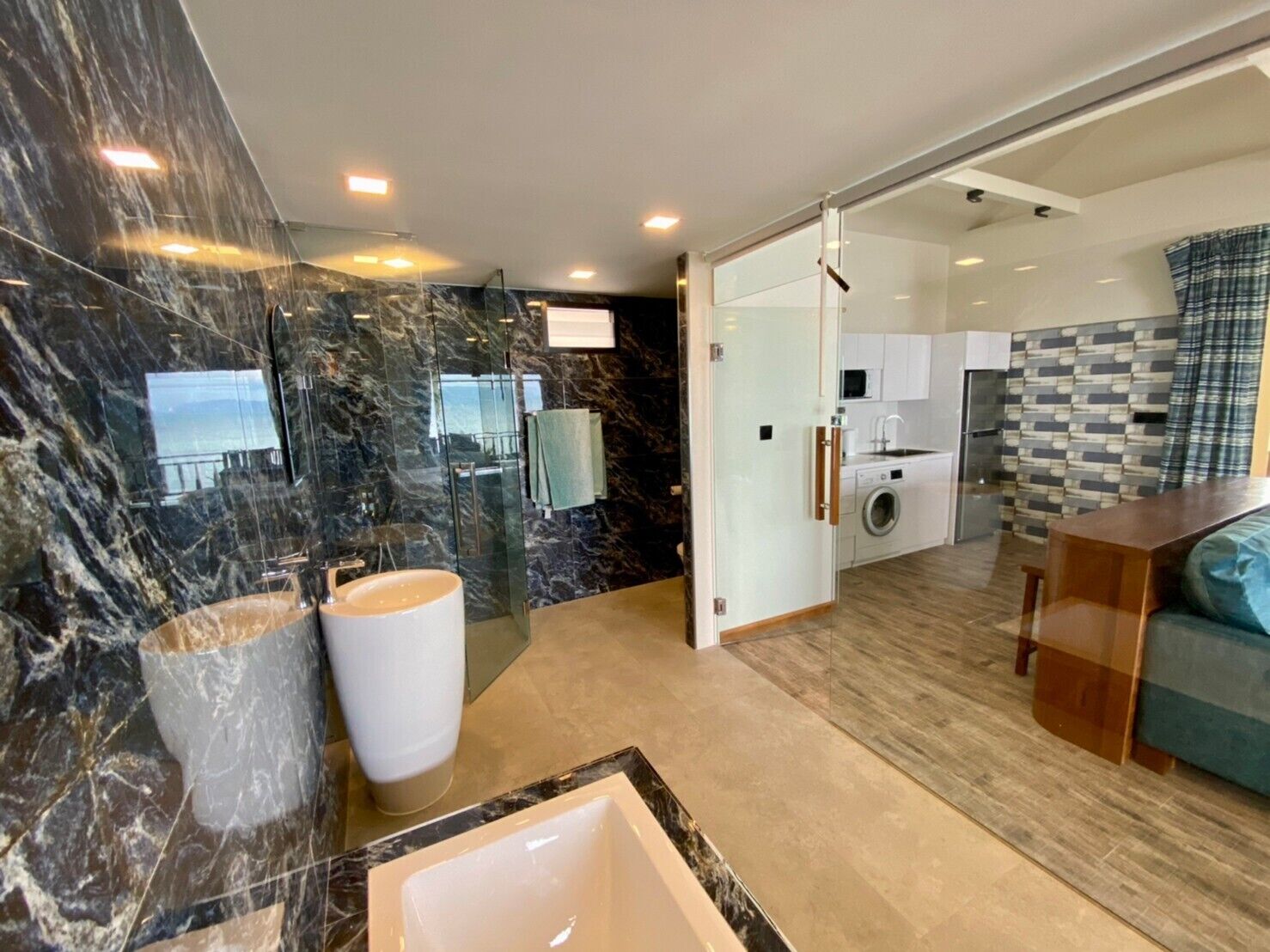 A modern bathroom with a large marble sink and a separate shower area.