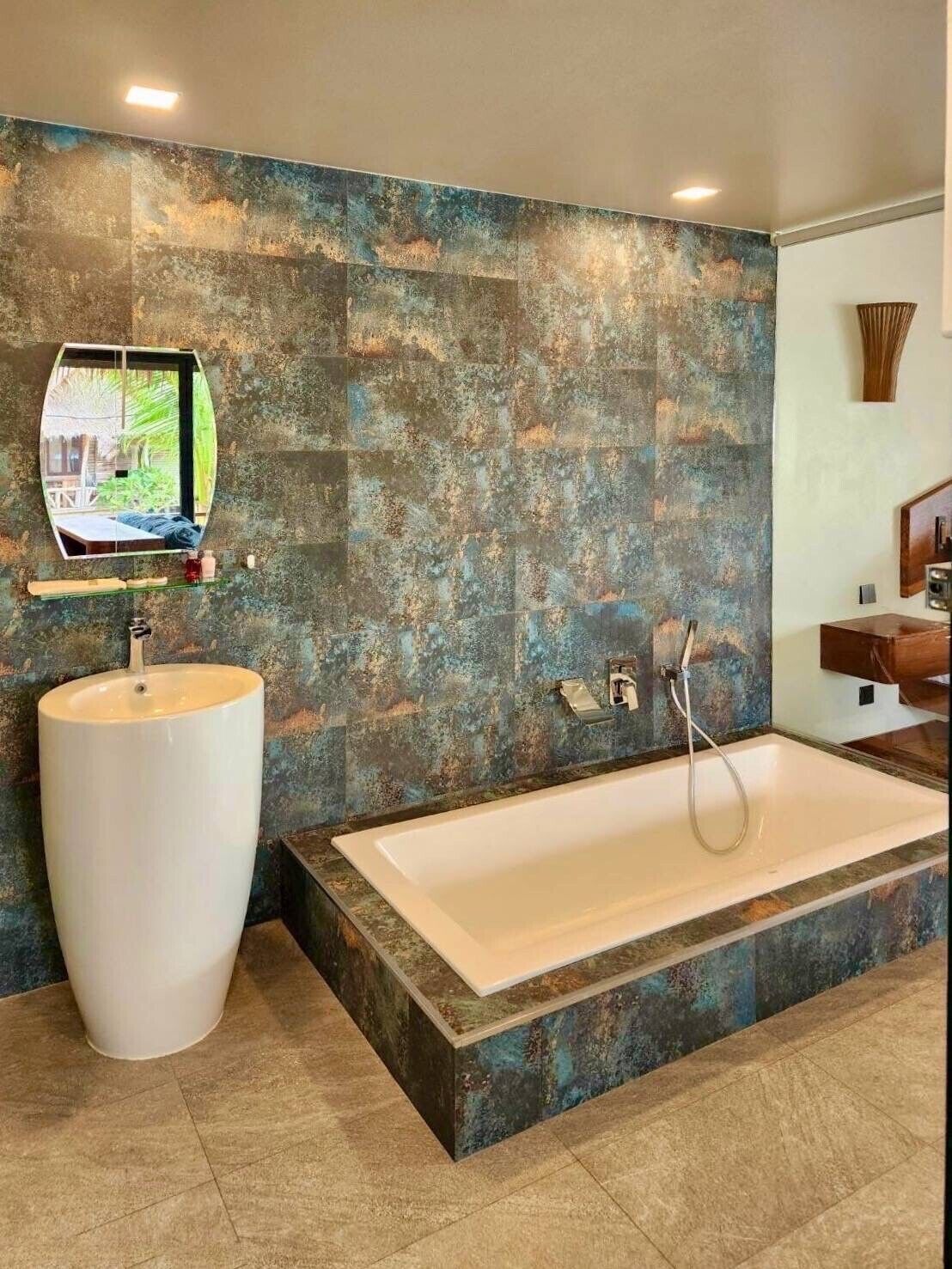 Un baño con una bañera grande, un lavabo redondo y un espejo.
