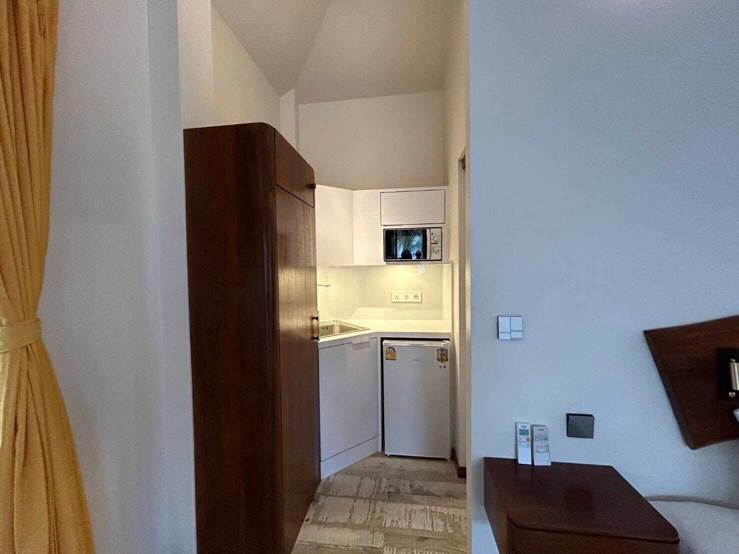 A compact kitchen with a microwave, a small refrigerator, and a sink.