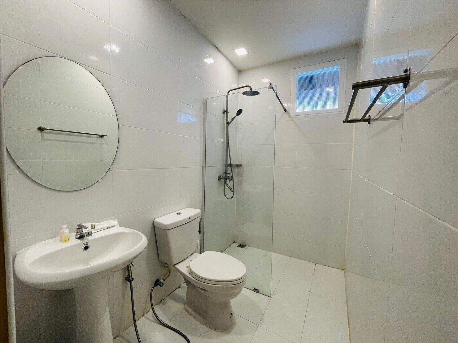 A modern bathroom with a toilet, sink, and shower.