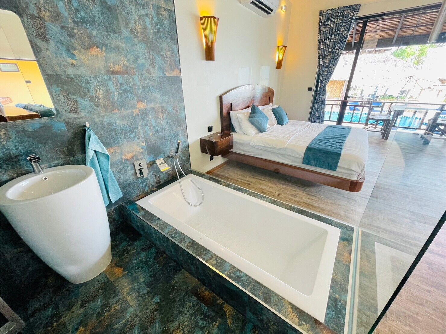 A modern bathroom with a large bathtub, a sink, and a mirror.
