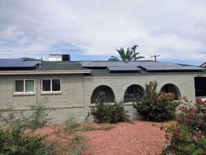 Residential building with solar panels and arched windows.