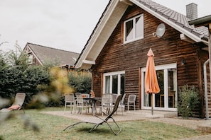 A wooden house with a patio, outdoor seating, and a satellite dish. - 'Haus Mimi Zarrentin' on Lake Schaalsee with Private Terrace & Garden (Zarrentin am Schaalsee)