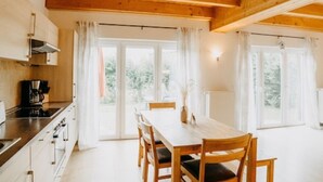 Un interior de madera con una mesa de comedor, sillas y una zona de cocina.