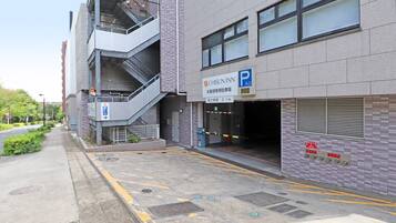 A building with a parking sign, a stairwell, and a gated entrance.