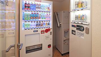 Máquina expendedora con el logotipo de Coca-Cola, un dispensador de agua y una sección refrigerada con bebidas.