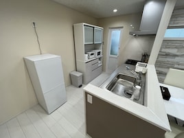 Cocina pequeña con refrigerador, microondas y lavamanos.