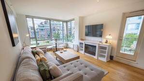 Una sala de estar moderna con un sofá grande, un televisor de pantalla plana y una chimenea.
