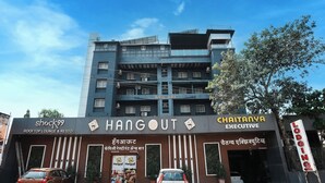 Un immeuble à plusieurs étages, sur lequel on peut lire les enseignes « Hangout Rooftop Lounge & Resto » et « Chaitanya Executive ».