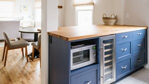 A modern kitchen with a wooden countertop, built-in oven, and blue cabinets. - Charming Renovated Cottage, Perfect Location, Walk to Everything, Across From Park & Cultural Center (Newberg)
