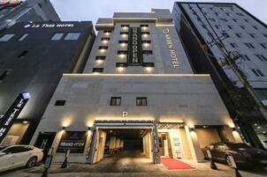 Entrada de hotel con un letrero que anuncia una gran inauguración.