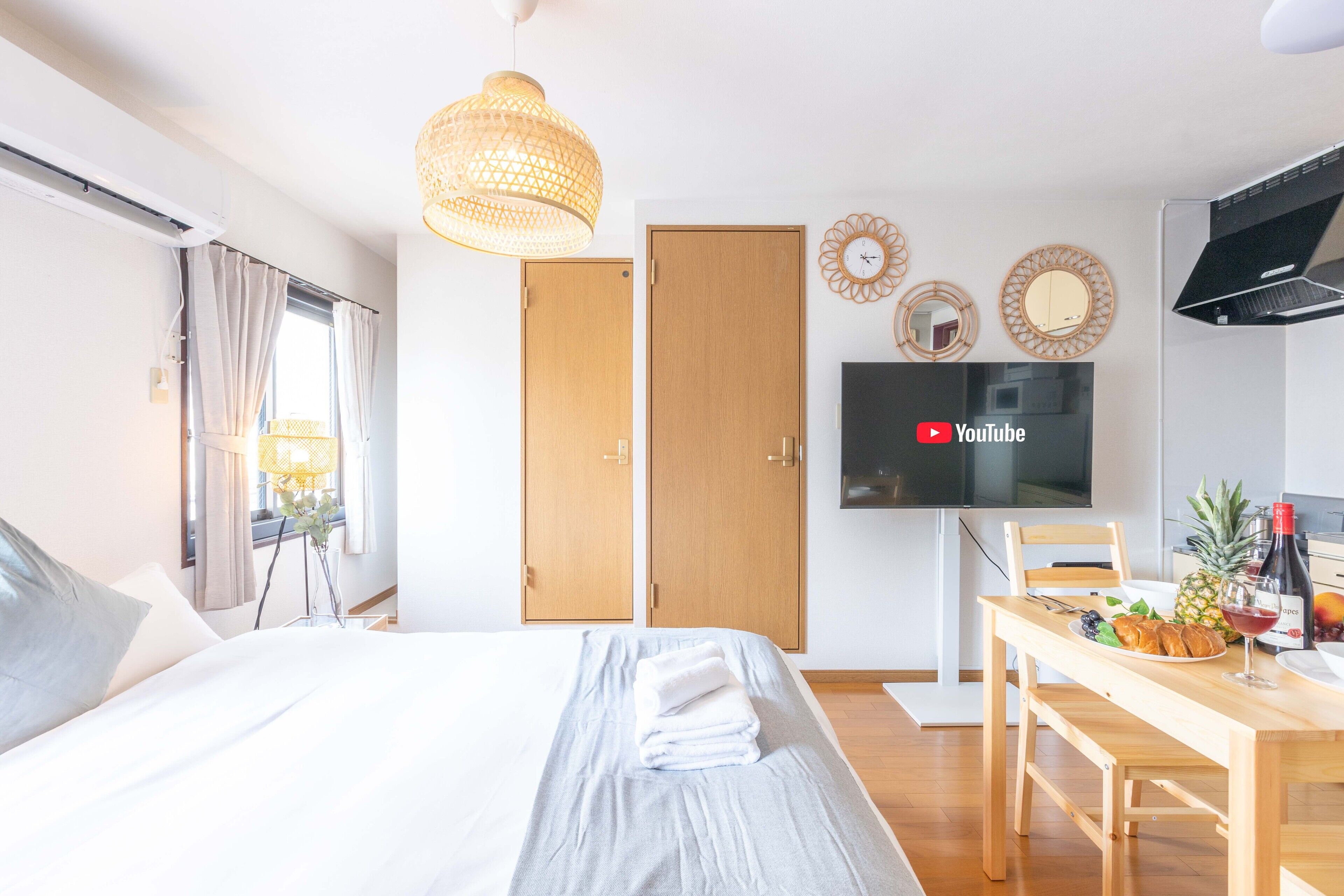 Habitación de hotel moderna con cama, una mesa de comedor con desayuno, televisor y el logotipo de YouTube en la pantalla.