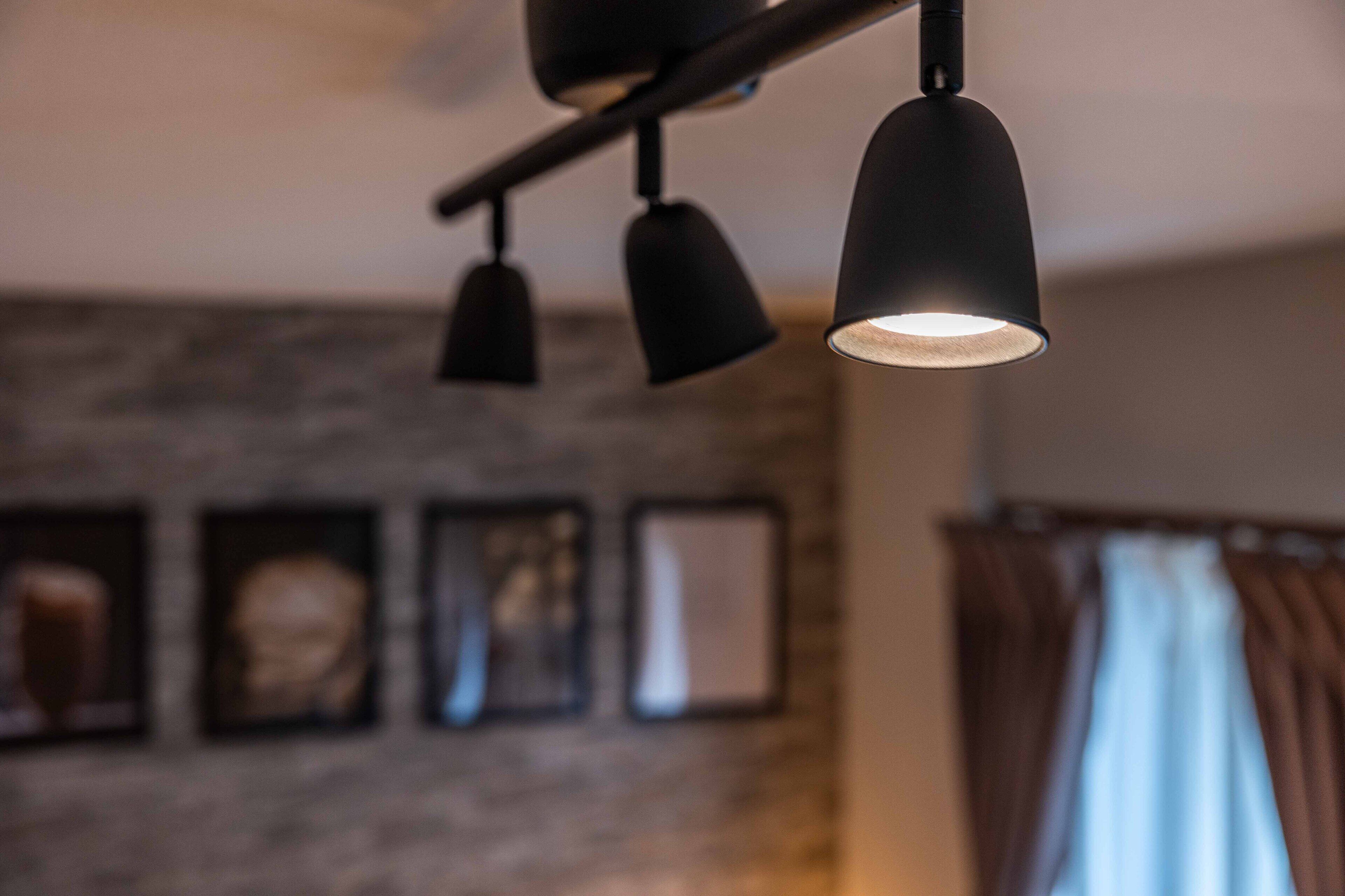 A modern interior with a ceiling-mounted lighting fixture and framed artwork on the wall.