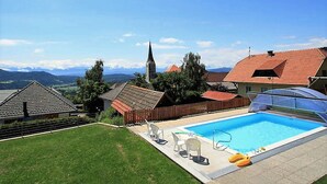 Una piscina con vistas a una iglesia y montañas al fondo.