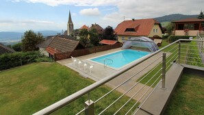 Un quartier résidentiel doté d’une piscine, d’une église et de maisons aux toits rouges.