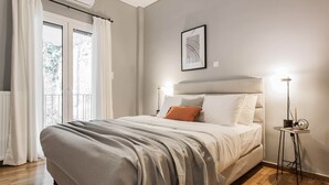 Une chambre à coucher avec un lit, une table de chevet, une lampe et une fenêtre avec des rideaux.