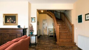 A spacious living room with a wooden staircase leading to an upper floor. - Villa Anastasia in Corfu (Corfu)
