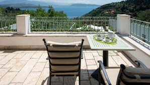 A terrace with two chairs and a table, overlooking a scenic view of a lake and hills. - Villa Anastasia in Corfu (Corfu)