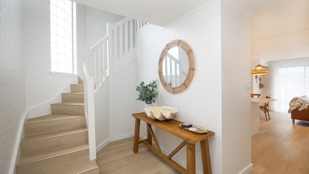 A staircase leading to a room with a wooden console table, a mirror, and a plant. - Breakers 5 - Beautifully renovated apartment just a stones throw from the beach (Mollymook)