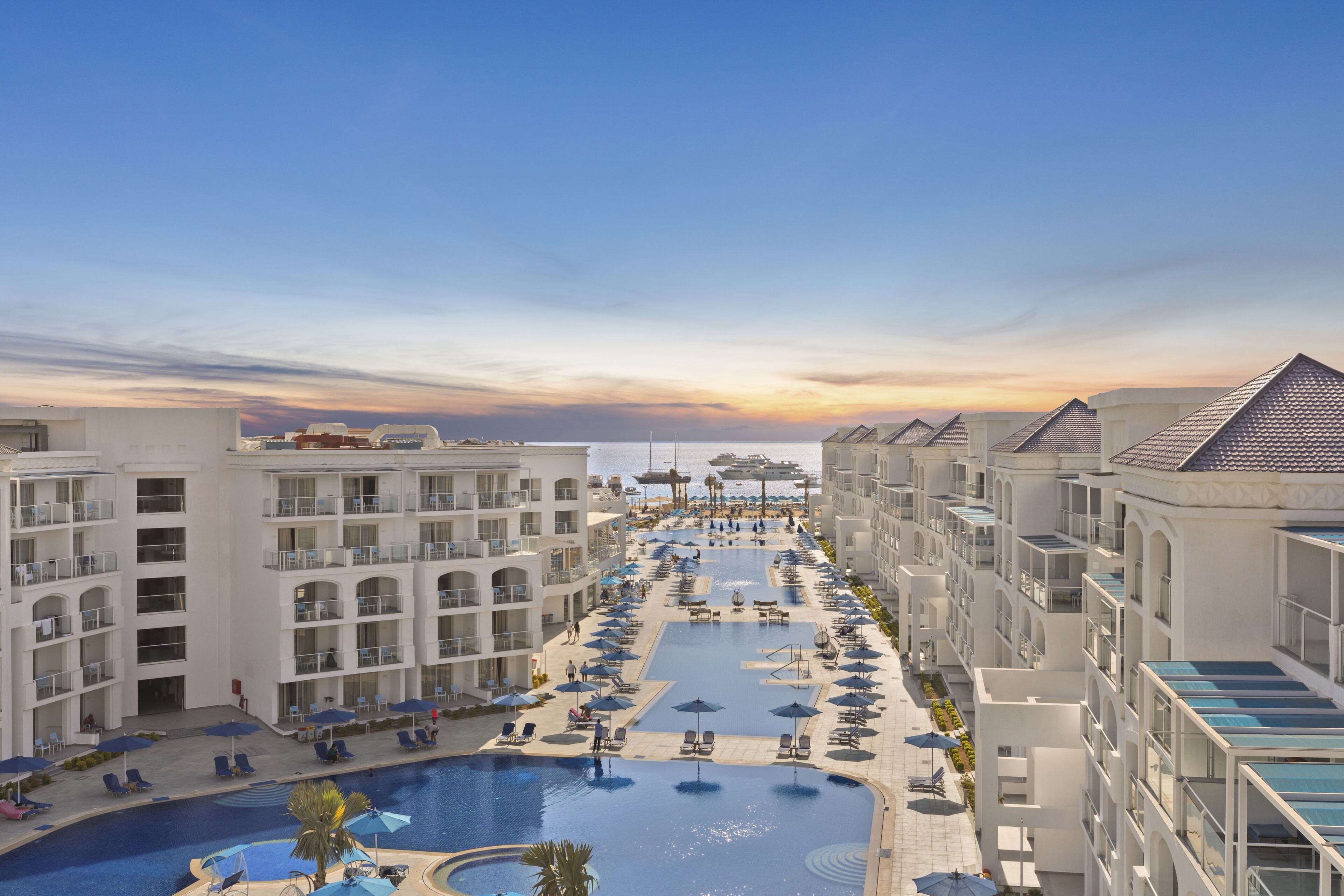 A resort with multiple swimming pools, sun loungers, and umbrellas.