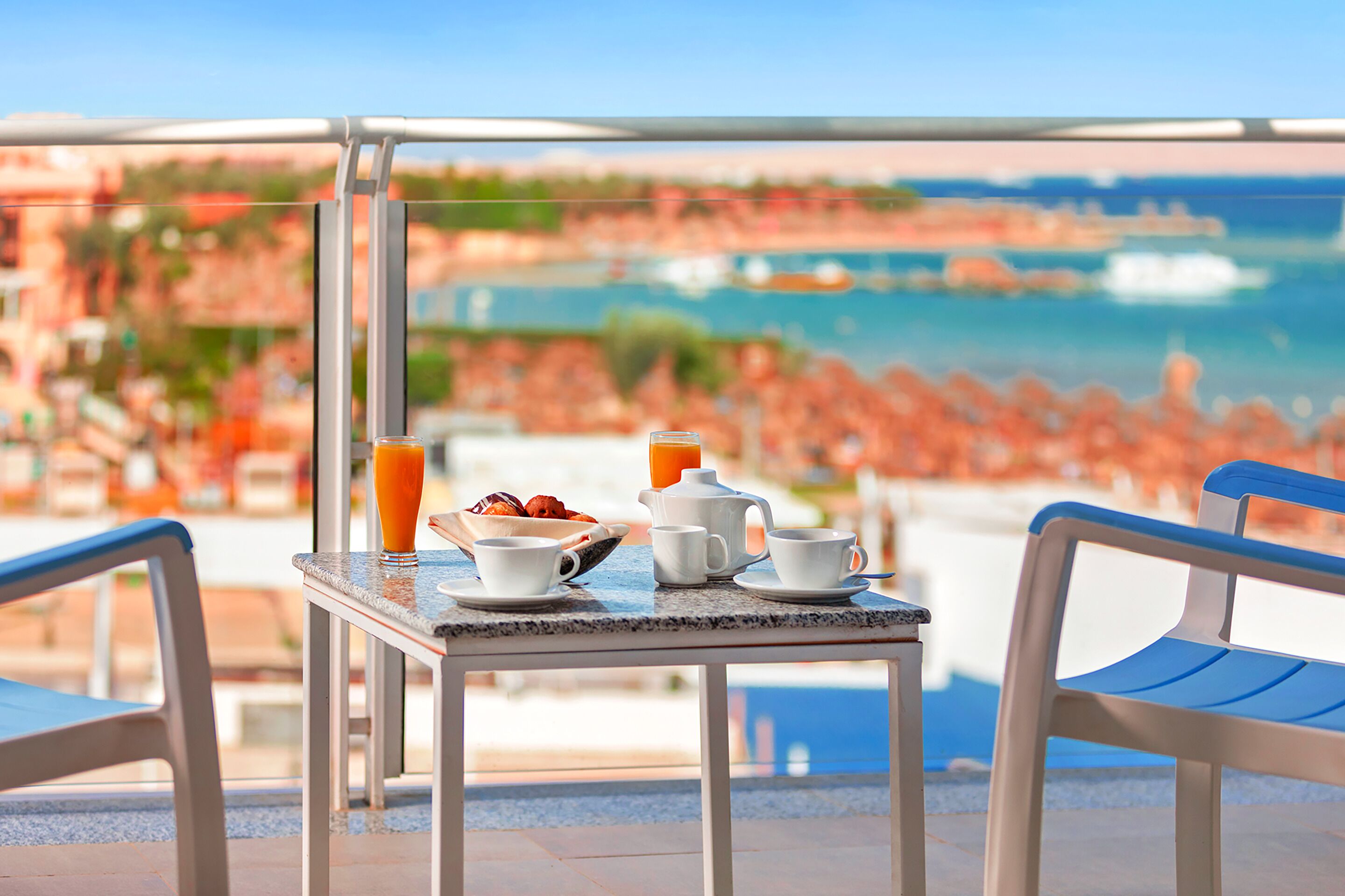 Un tavolo con prodotti per la colazione e vista sulla spiaggia e sull'oceano.