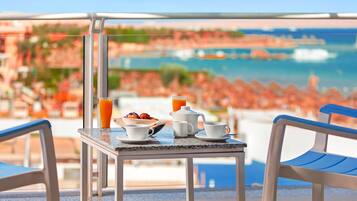 Un tavolo con prodotti per la colazione e vista sulla spiaggia e sull'oceano.