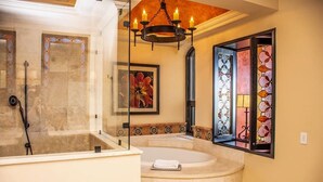 Un baño con bañera, ducha y ventana con vidrieras.