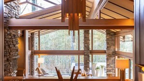 A dining area with a large window, stone wall, and wooden beams. - Hunter House - Hot tub & movie theater (Memphis)