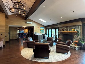 A spacious lobby with leather sofas, a fireplace, and a reception desk.
