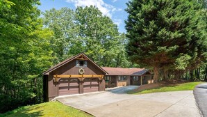 A two-story building with a garage, surrounded by trees. - Peace of Heaven in Connestee Falls (Brevard)