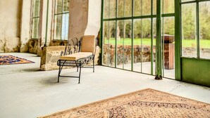 An interior with arched windows, a bench, and a rug. - Chateau du Hallay (Montaigu-Vendée)
