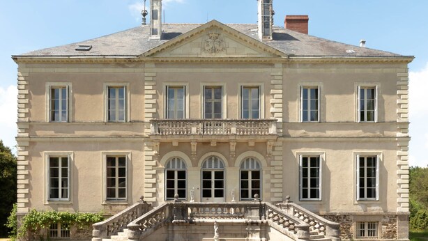 A large, stately building with a symmetrical facade, multiple windows, and a central entrance with a staircase. - Chateau du Hallay (Montaigu-Vendée)