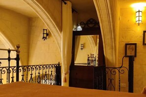 A room with a bed, a wooden headboard, a mirror, and a wall-mounted light fixture. - 2 Bed House Sleeps 3 - Wifi, Aircon, Balcony (Valletta)