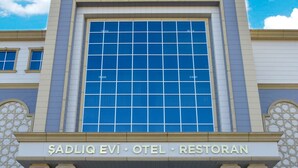 A building with a large glass facade and a sign reading "NAXCIVAN PALACE". - Naxçıvan Palace Hotel (Nakhchivan)